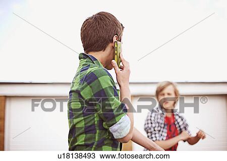 Boy on cell phone View Large Photo Image Stock Image - Boy on cell phone. Fotosearch