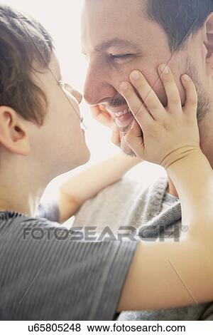 Stock Photo - Boy showing affection to father. Fotosearch