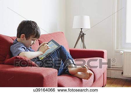 Stock Photograph - Boy using digital tablet. Fotosearch