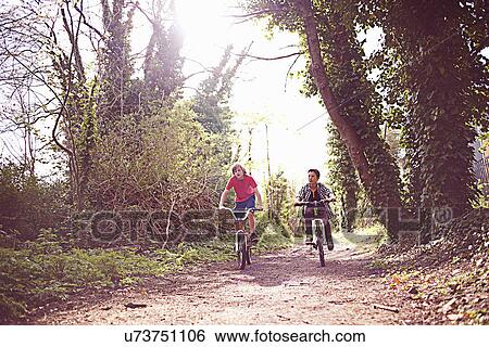 Boys cycling on forest path View Large Photo Image Stock Photograph - Boys cycling on forest path. Fotosearch