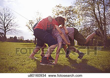 Boys play fighting on playing field View Large Photo Image Picture - Boys play fighting on playing field. Fotosearch