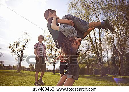 Stock Photo - Boys play fighting on playing field. Fotosearch