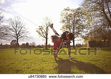 Stock Photography - Boys play fighting on playing field. Fotosearch