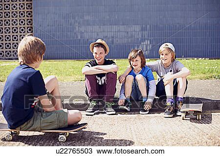 Boys sitting on pavement with skateboards View Large Photo Image Stock Image - Boys sitting on pavement with skateboards. Fotosearch