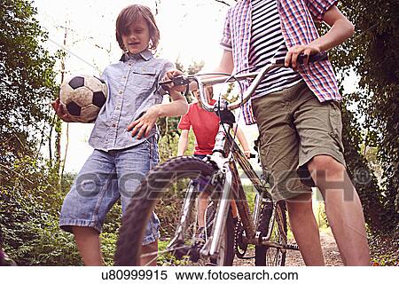 Stock Photography - Boys with bikes and football. Fotosearch