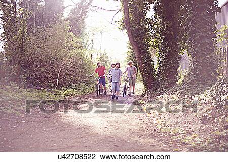 Boys with bikes on forest path View Large Photo Image Stock Image - Boys with bikes on forest path. Fotosearch