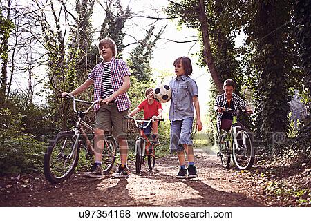 Boys with bikes on forest path View Large Photo Image Stock Photo - Boys with bikes on forest path. Fotosearch