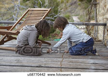 Brother and sister making a row of dried beans on balcony View Large Photo Image Stock Image - Brother and sister making a row of dried beans on balcony. Fotosearch