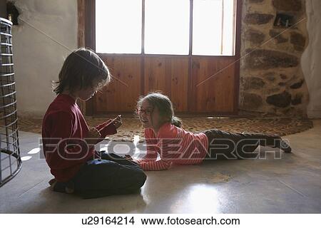 Brother and sister playing in living room View Large Photo Image Picture - Brother and sister playing in living room. Fotosearch