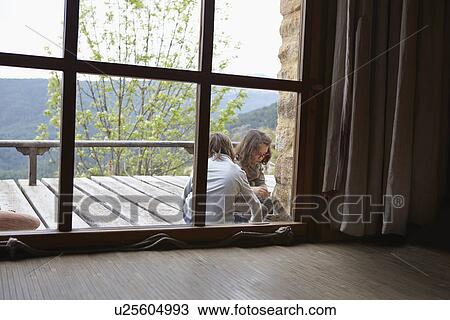 Stock Image - Brother and sister playing together on patio. Fotosearch