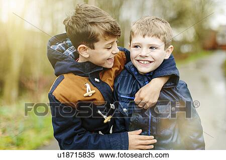Stock Photography - Brothers hugging outdoors. Fotosearch