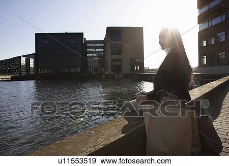 Business woman taking break by waterfront, Copenhagen, Denmark View Large Photo Image Stock Photo - Business woman taking break by waterfront, Copenhagen, Denmark. Fotosearch