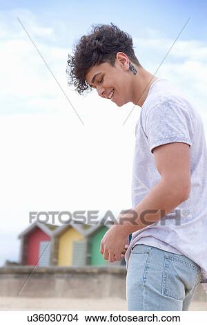 Picture - Candid portrait of young man at beach. Fotosearch