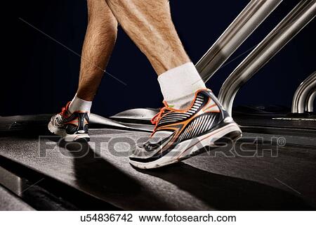 Close up of male legs running on gym treadmill in altitude centre View Large Photo Image Stock Image - Close up of male legs running on gym treadmill in altitude centre. Fotosearch