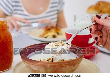Stock Photography - Close up of mother and teenage daughter sharing breakfast. Fotosearch