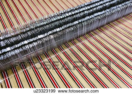 Stock Photo - Close up of striped textile on weaving machine in woollen mill. Fotosearch