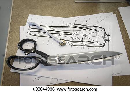 Stock Photograph - Detail of fashion drawings and scissors in fashion studio. Fotosearch
