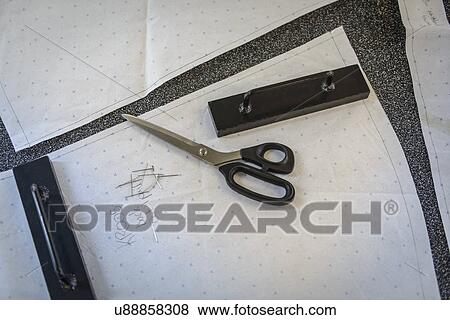 Stock Photo - Detail of fashion drawings, fabric and scissors in fashion studio. Fotosearch