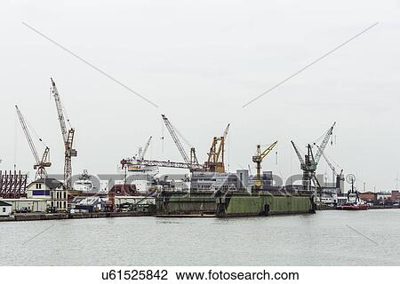 Dry dock and dock cranes in the background, Bremerhaven, Germany View Large Photo Image Stock Image - Dry dock and dock cranes in the background, Bremerhaven, Germany. Fotosearch