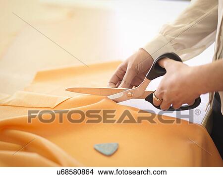 Fashion designer cutting cloth in fashion design studio, close up View Large Photo Image Picture - Fashion designer cutting cloth in fashion design studio, close up. Fotosearch