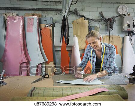 Stock Photo - Fashion designer marking up cloth in clothing factory. Fotosearch