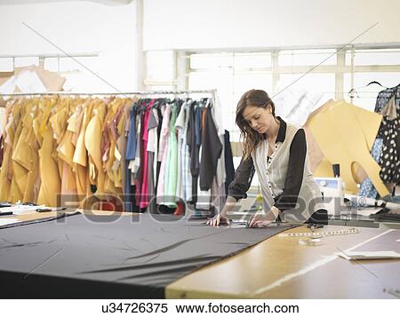 Fashion designer measuring fabric in fashion design studio View Large Photo Image Stock Photography - Fashion designer measuring fabric in fashion design studio. Fotosearch