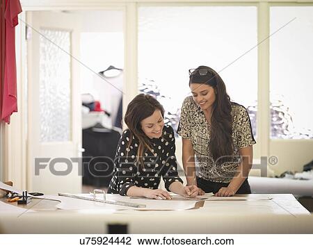 Stock Image - Fashion designers working together in fashion studio. Fotosearch