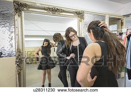 Stock Image - Fashion designers working together on dress in fashion studio. Fotosearch