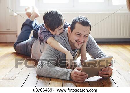 Father and son self-photographing with digital tablet View Large Photo Image Stock Photo - Father and son self-photographing with digital tablet. Fotosearch