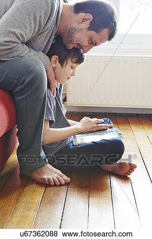 Stock Photo - Father and son using digital tablet. Fotosearch