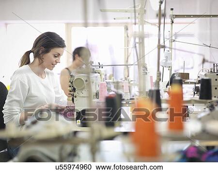 Stock Image - Female garment worker in clothing factory. Fotosearch