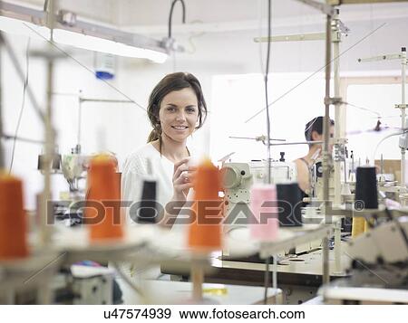 Stock Photo - Female garment worker in clothing factory, portrait. Fotosearch
