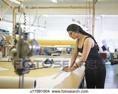 Female garment worker marking cloth in clothing factory View Large Photo Image Picture - Female garment worker marking cloth in clothing factory. Fotosearch