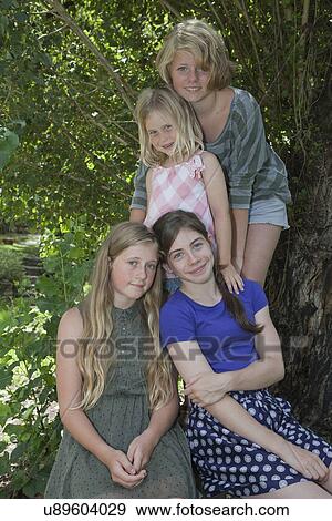 Four girls beside tree View Large Photo Image Stock Photo - Four girls beside tree. Fotosearch