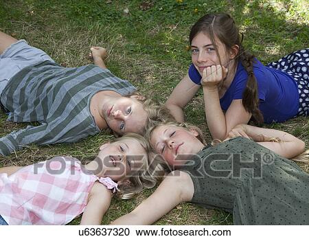 Four girls lying on grass View Large Photo Image Stock Image - Four girls lying on grass. Fotosearch