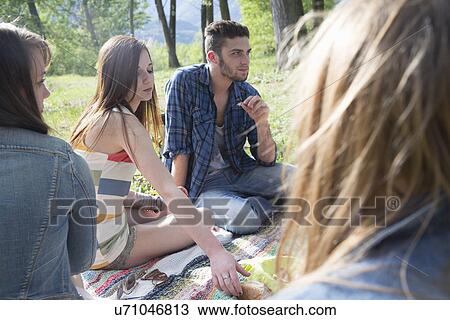 Friends sitting having picnic View Large Photo Image Stock Image - Friends sitting having picnic. Fotosearch