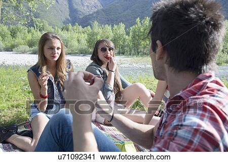 Friends sitting having picnic View Large Photo Image Stock Image - Friends sitting having picnic. Fotosearch