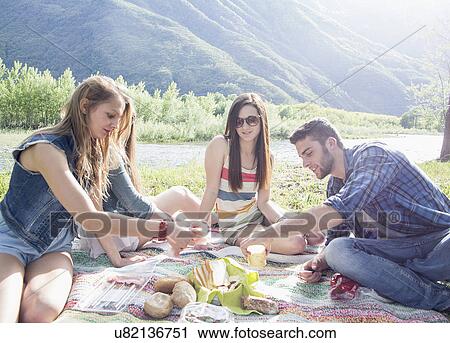 Friends sitting having picnic View Large Photo Image Stock Image - Friends sitting having picnic. Fotosearch