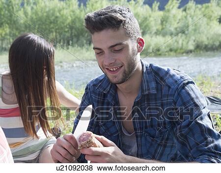 Stock Photo - Friends sitting having picnic. Fotosearch