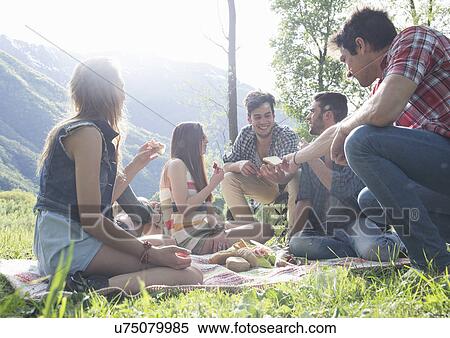 Stock Photography - Friends sitting having picnic. Fotosearch