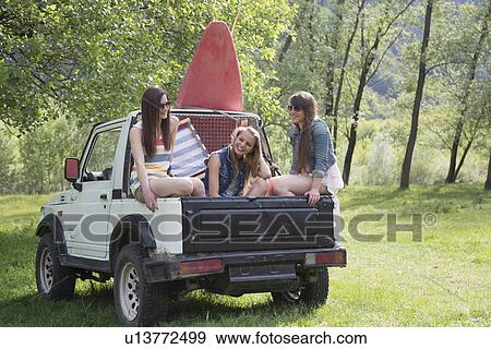 Friends sitting on back of off road vehicle View Large Photo Image Stock Photo - Friends sitting on back of off road vehicle. Fotosearch