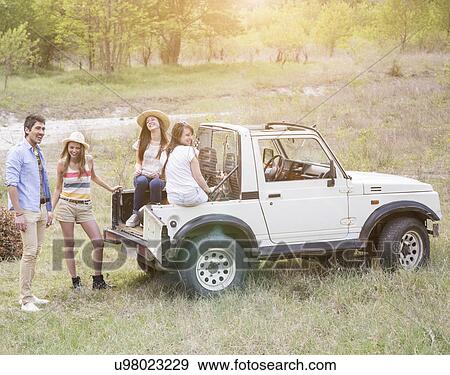 Friends sitting on back of off road vehicle View Large Photo Image Stock Photo - Friends sitting on back of off road vehicle. Fotosearch