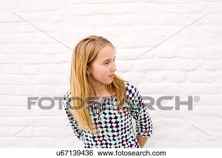 Stock Photograph - Girl leaning forward from white wall. Fotosearch