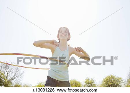 Girl playing with plastic hoop View Large Photo Image Stock Photograph - Girl playing with plastic hoop. Fotosearch