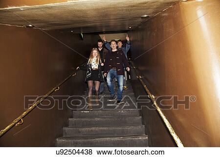 Group of friends coming down stairs into nightclub View Large Photo Image Stock Photo - Group of friends coming down stairs into nightclub. Fotosearch