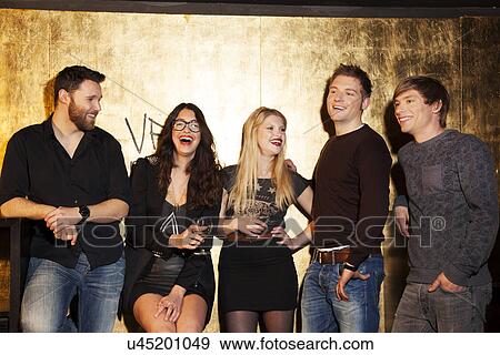 Stock Photo - Group of friends having a laugh in nightclub. Fotosearch