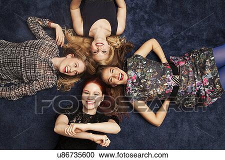 Group of friends lying on carpeted floor View Large Photo Image Stock Image - Group of friends lying on carpeted floor. Fotosearch