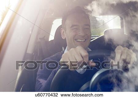 Stock Image - Happy man behind wheel of car. Fotosearch