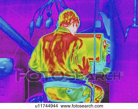 Infra red heat image of worker and heat loss at computer work station View Large Photo Image Picture - Infra red heat image of worker and heat loss at computer work station. Fotosearch