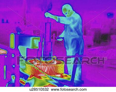 Stock Image - Infra red heat image of worker fitting cold shaft into hot gears in factory. Fotosearch